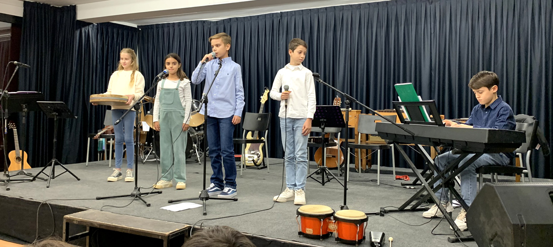 Varios alumnos de 5º Educación Primaria del Centro Educativo Gençana están en el escenario recitando poesía