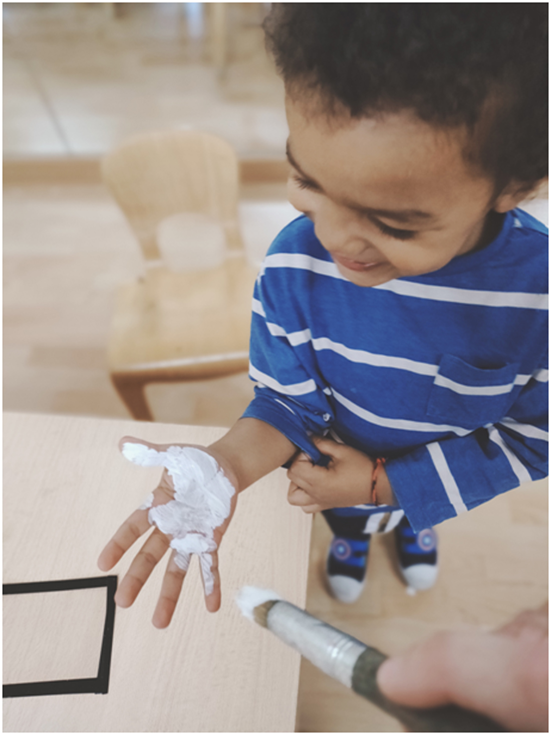 niño con mano pintada de pintura blanca