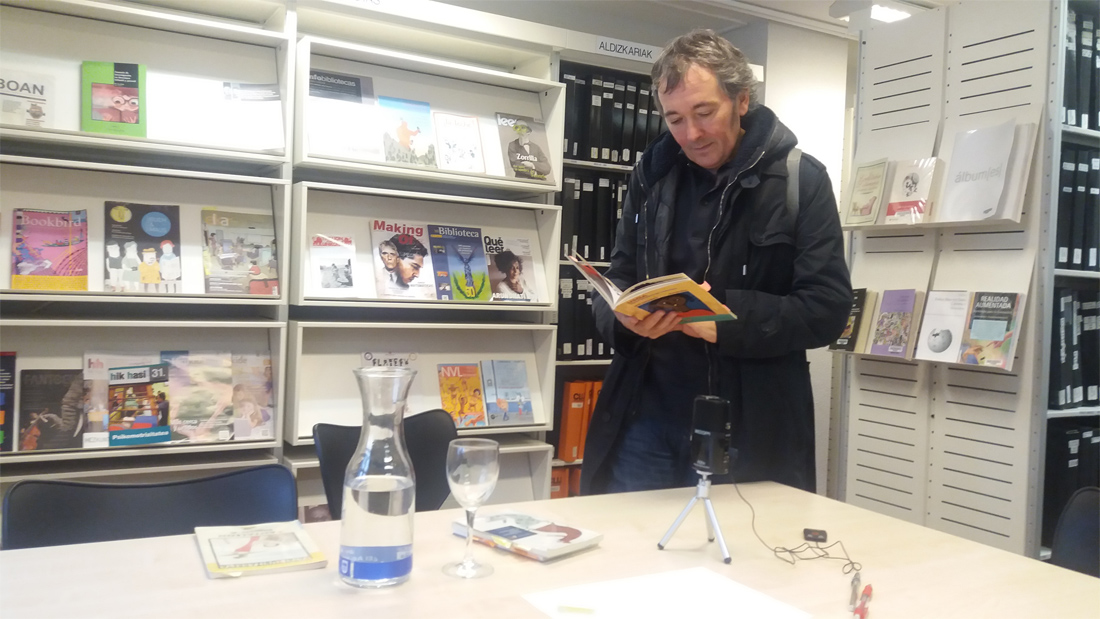 Patxi Zubizarreta, ilustrador, hojea un libro en un stand
