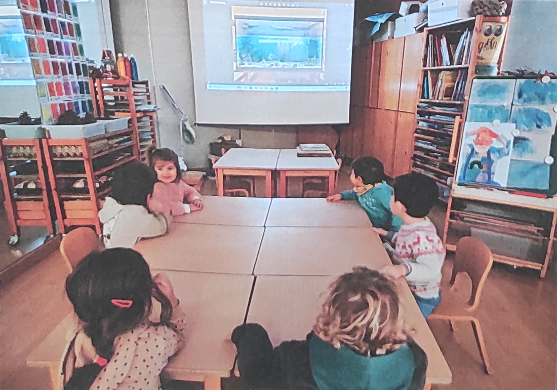 Un grupo de niños está en el Centro Educativo Gençana, en el taller de alfabetización visual, viendo imágenes de animales marinos y charlando sobre ellas
