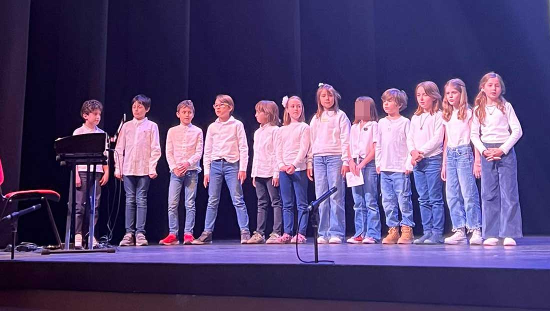 Un grupo de alumnos y alumnas de 3º Primaria del Centro Educativo Gençana cantan una canción en el escenario durante la celebración de la XII Trobada Musical de l'Horta Nord
