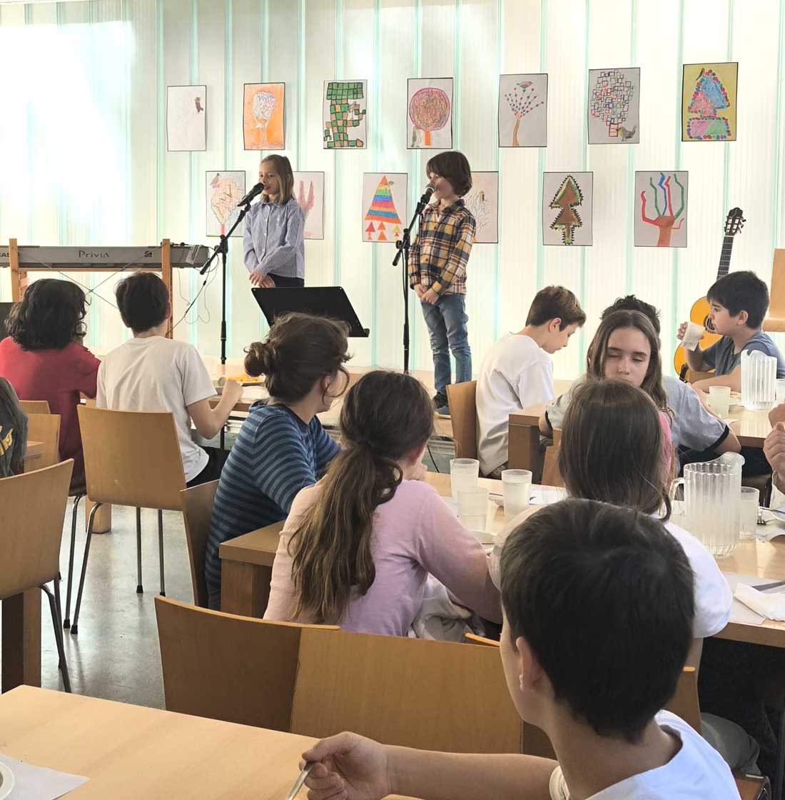 Dos alumnos de Gençana subidos a un escenario recitando poesía