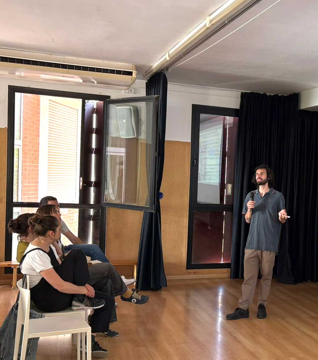 Pablo Hidalgo, psicólogo sanitario, imparte una charla en el Centro Educativo Gençana mientras tres mujeres lo escuchan sentadas en primera fila